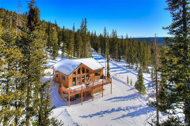 snow covered house featuring a deck