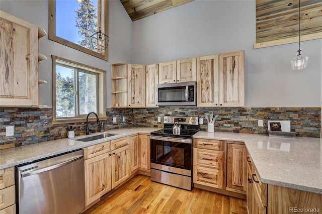 kitchen featuring hanging light fixtures, appliances with stainless steel finishes, sink, and light brown cabinets