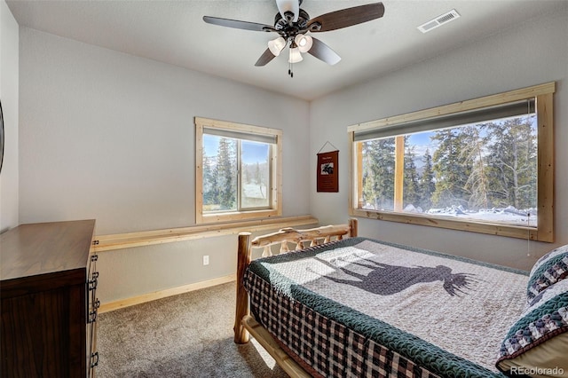 carpeted bedroom featuring multiple windows and ceiling fan