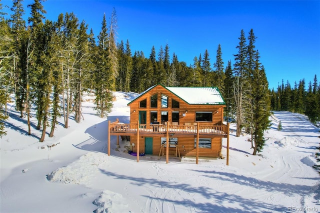 snow covered property with a wooden deck