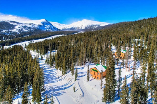 snowy aerial view with a forest view and a mountain view