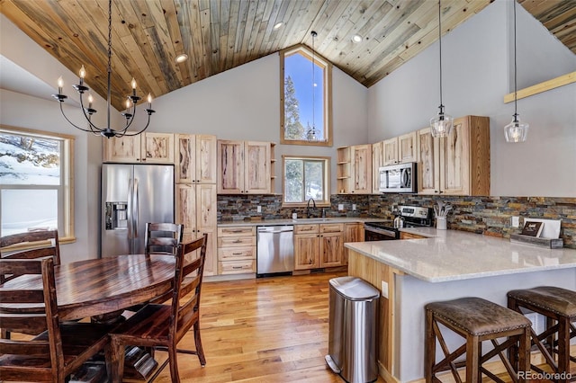 207 Pine Cone Way, Fairplay, CO 80440 - kitchen featuring appliances with stainless steel finishes, light brown cabinetry, a peninsula, light wood finished floors, and high vaulted ceiling