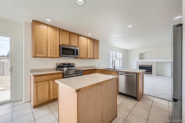 kitchen with stainless steel appliances, sink, light tile patterned floors, and kitchen peninsula