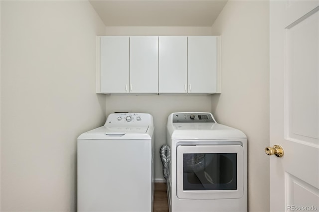 washroom featuring cabinets and washer and clothes dryer