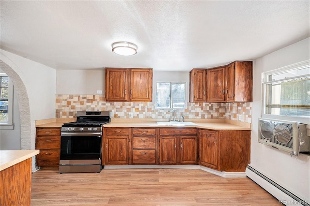 kitchen featuring plenty of natural light, sink, a baseboard radiator, and gas range