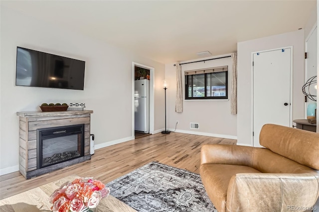 3224 Troy St, Aurora, CO 80011 - living area featuring wood finished floors, baseboards, and a glass covered fireplace