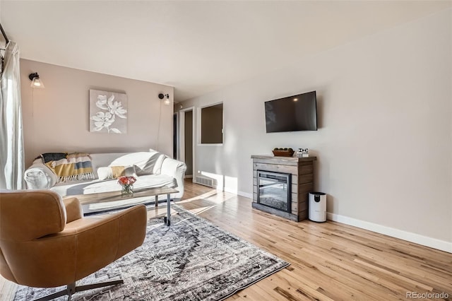 3224 Troy St, Aurora, CO 80011 - living area featuring wood finished floors, baseboards, and a glass covered fireplace