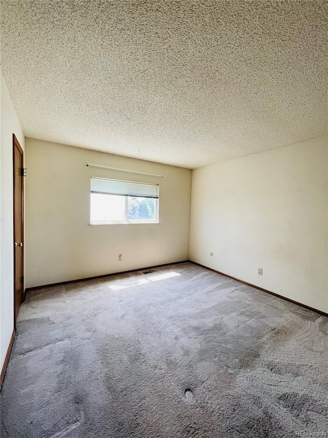 carpeted spare room with a textured ceiling