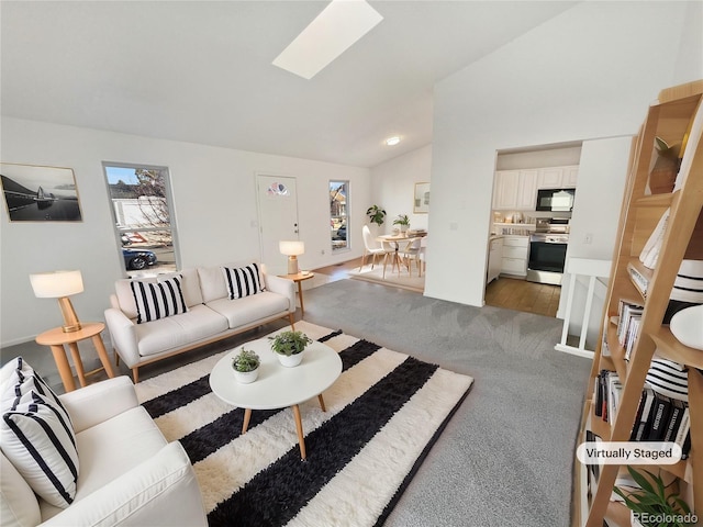 carpeted living area featuring vaulted ceiling with skylight