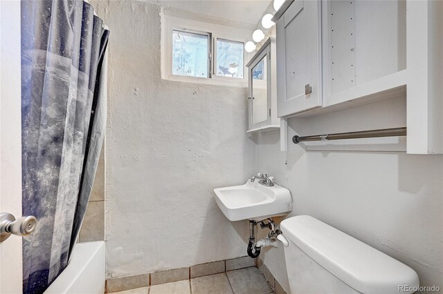 full bathroom featuring tile patterned flooring, toilet, shower / tub combo with curtain, and sink