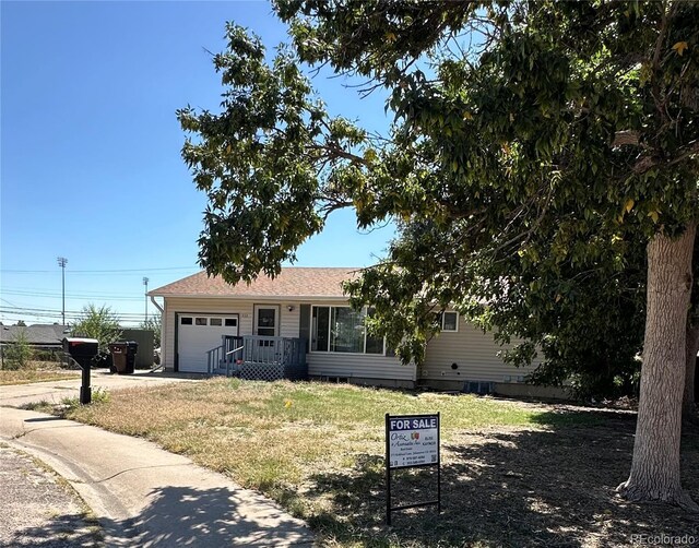 ranch-style house with a garage and a front lawn