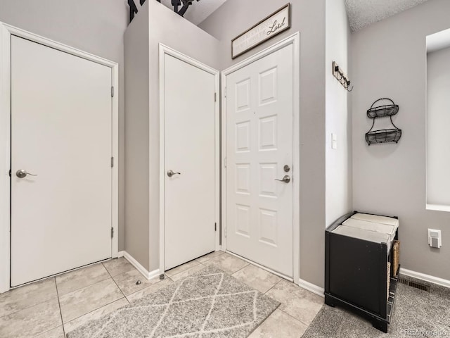 tiled foyer with a textured ceiling