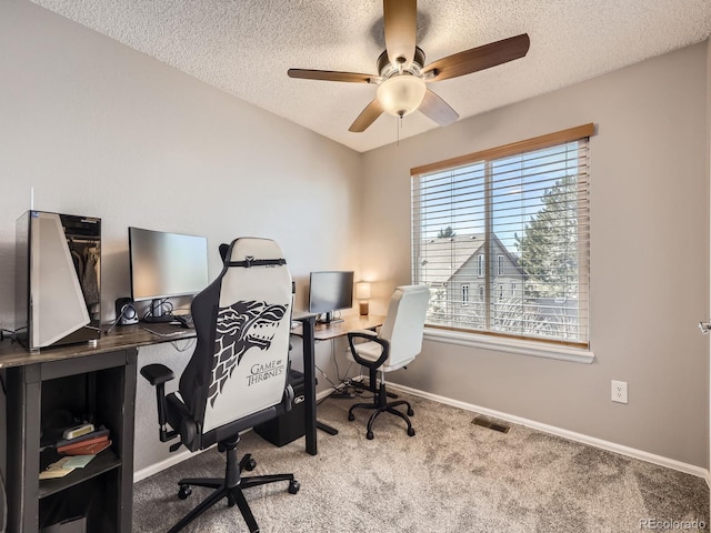 home office with light carpet, ceiling fan, and a textured ceiling