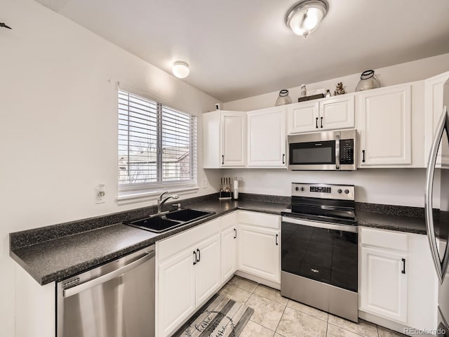 kitchen featuring sink, white cabinets, light tile patterned floors, and appliances with stainless steel finishes