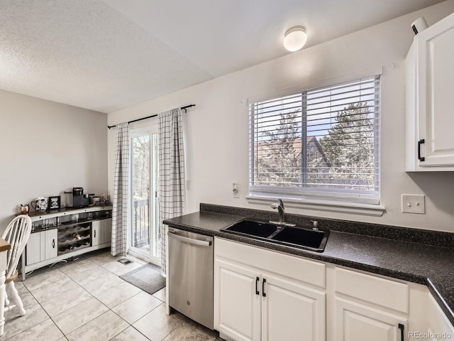 kitchen featuring white cabinetry, sink, stainless steel dishwasher, and plenty of natural light