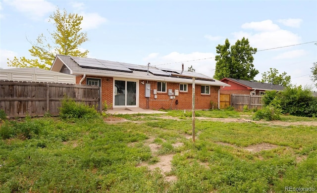 3341 W 94th Ave, Westminster, CO 80031 - back of property with solar panels, a fenced backyard, brick siding, and a patio