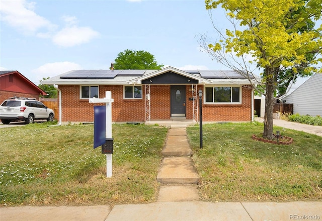 3341 W 94th Ave, Westminster, CO 80031 - view of front of home with brick siding, a front lawn, and roof mounted solar panels