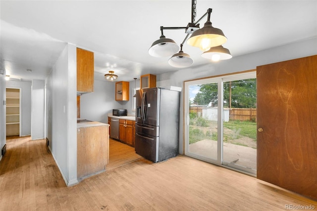 3341 W 94th Ave, Westminster, CO 80031 - kitchen with stainless steel appliances, brown cabinetry, light countertops, and light wood finished floors
