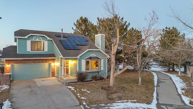 view of front of property with a garage and solar panels