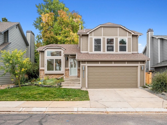 view of front of house with an attached garage, concrete driveway, stucco siding, and a front lawn