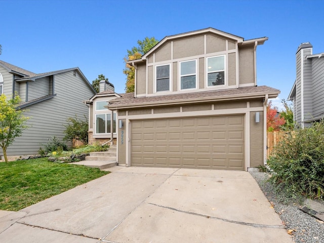 traditional-style home featuring a garage, driveway, and stucco siding