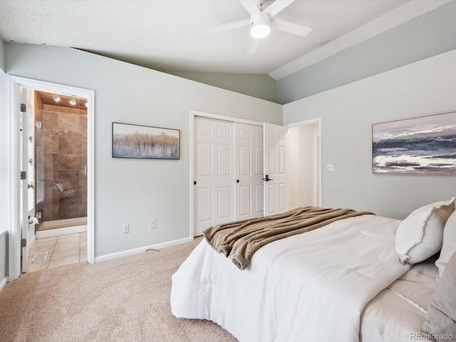 bedroom featuring baseboards, a closet, vaulted ceiling, light carpet, and connected bathroom