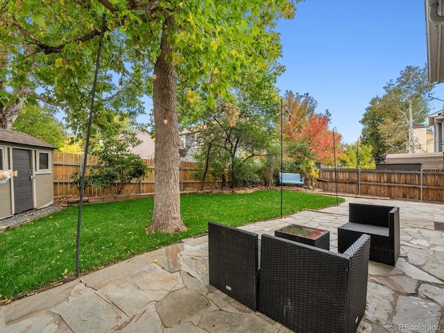 view of patio / terrace featuring an outbuilding, a fenced backyard, and a storage unit