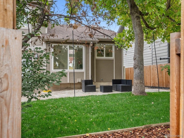 back of house featuring a yard, a patio area, fence, and stucco siding