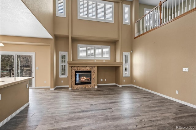 unfurnished living room with a glass covered fireplace, wood finished floors, and a healthy amount of sunlight