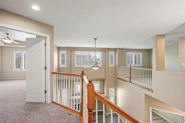 hall featuring an upstairs landing, recessed lighting, and carpet floors