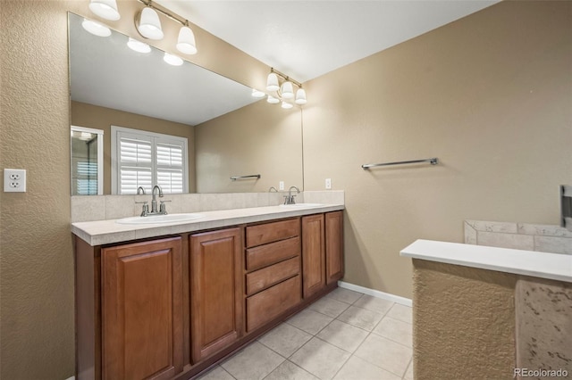 bathroom with a sink, baseboards, double vanity, and tile patterned floors