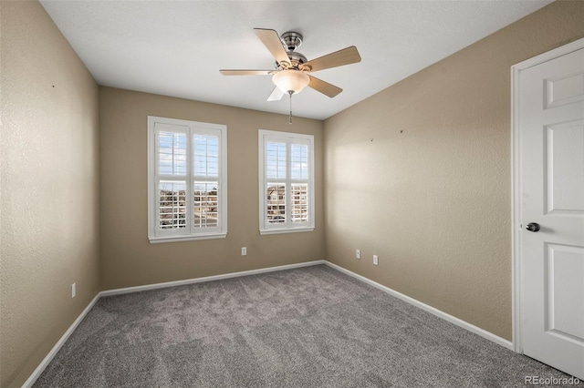 spare room featuring a ceiling fan, carpet, baseboards, and a textured wall