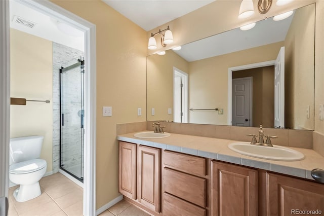 full bath featuring double vanity, a shower stall, toilet, and a sink