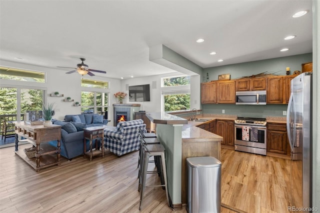 107 Mountain Vista Ln, Silverthorne, CO 80498 - kitchen featuring stainless steel appliances, a peninsula, open floor plan, light wood-style floors, and a breakfast bar