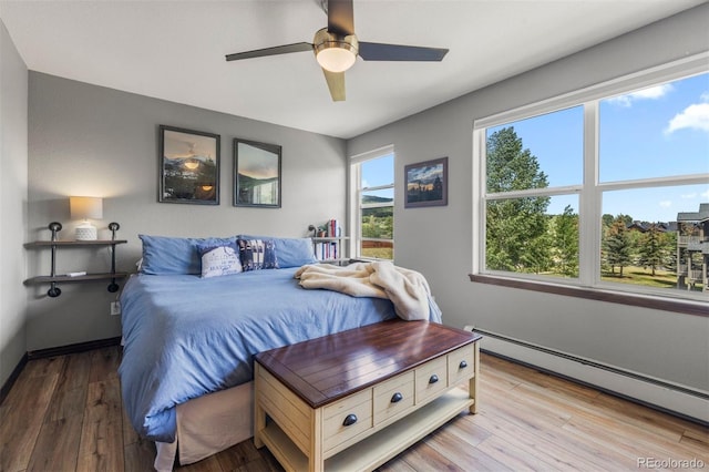 107 Mountain Vista Ln, Silverthorne, CO 80498 - bedroom with a baseboard radiator, wood finished floors, and ceiling fan