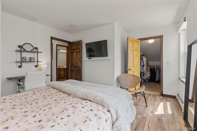 107 Mountain Vista Ln, Silverthorne, CO 80498 - bedroom featuring light wood finished floors, a baseboard heating unit, a spacious closet, and a closet