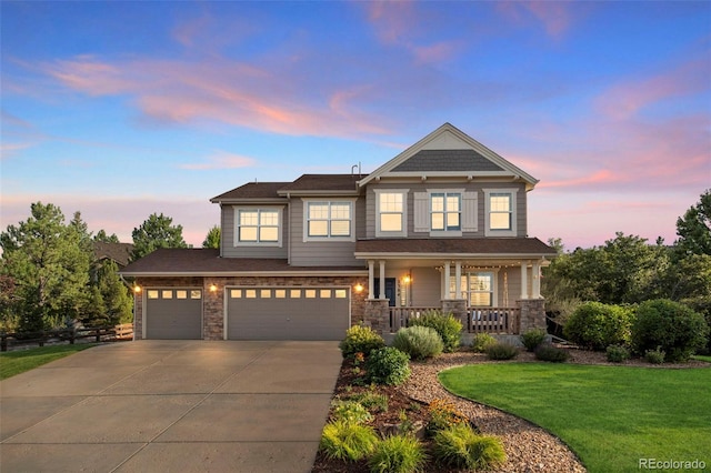 craftsman-style house featuring a porch, a garage, and a yard