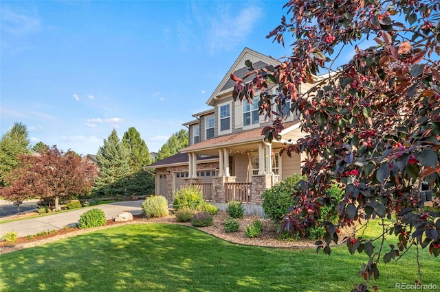 view of front of house featuring a porch, a garage, and a front yard