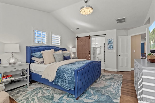 bedroom with hardwood / wood-style flooring, vaulted ceiling, and a barn door