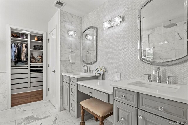 bathroom with vanity, tile walls, and walk in shower