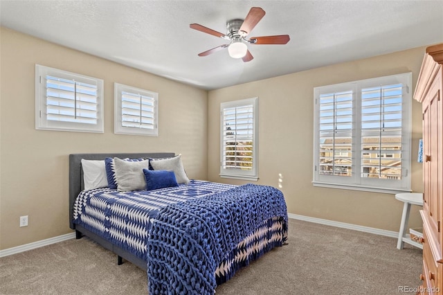 carpeted bedroom featuring ceiling fan and a textured ceiling