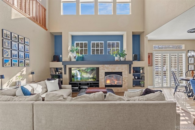 living room with a high ceiling and a tile fireplace