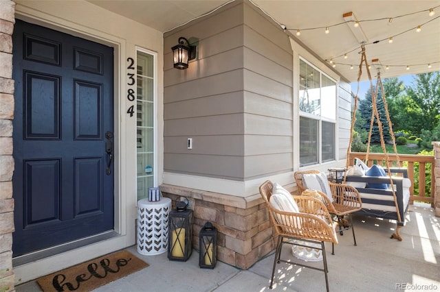 view of exterior entry featuring covered porch