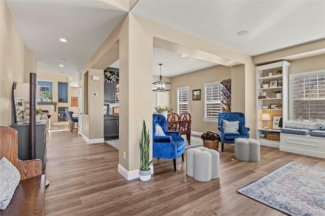 sitting room featuring plenty of natural light, hardwood / wood-style floors, and an inviting chandelier