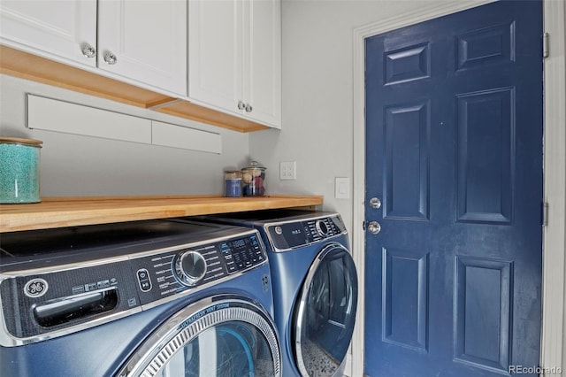 laundry area featuring washer and clothes dryer and cabinets