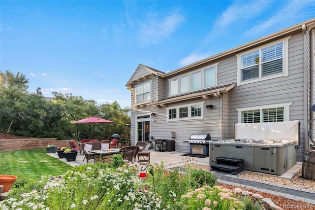 back of house with a patio area, a hot tub, and an outdoor fire pit