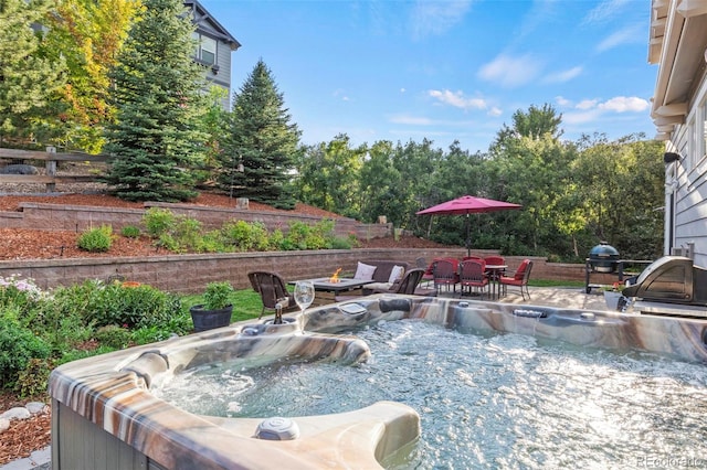 view of patio / terrace featuring a hot tub and a fire pit