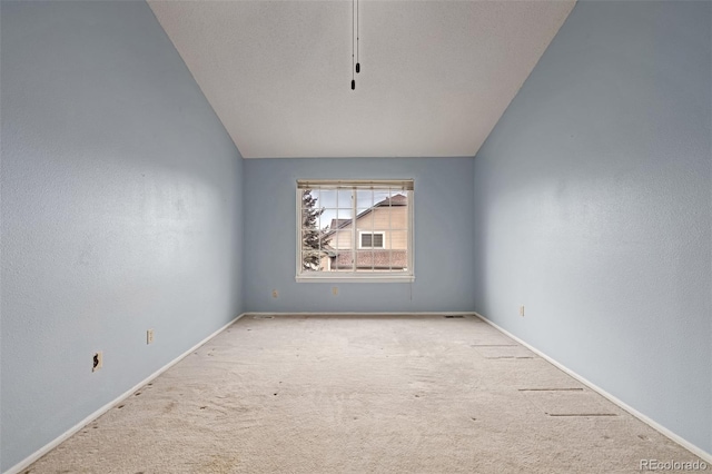 carpeted empty room with lofted ceiling and a textured ceiling