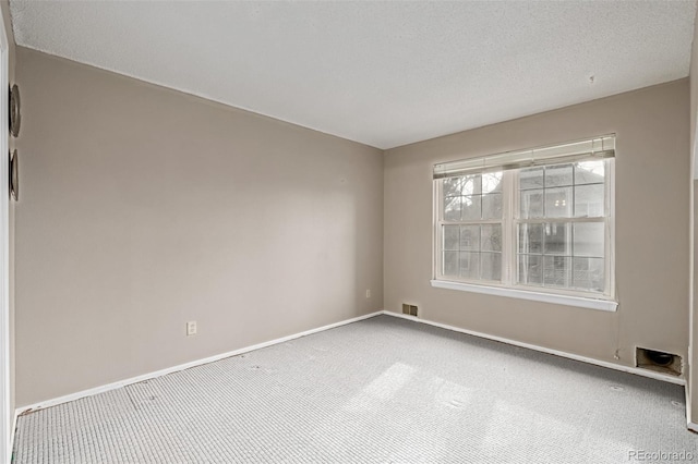 spare room with carpet floors and a textured ceiling