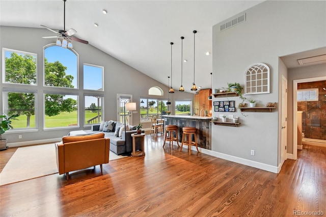 6776 Salvia Ct, Arvada, CO 80007 - living area with high vaulted ceiling, ceiling fan, plenty of natural light, and light wood-type flooring